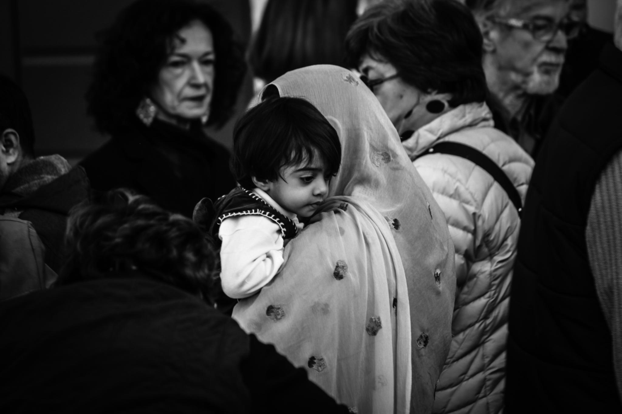 zwei Frauen tragen einen Jungen